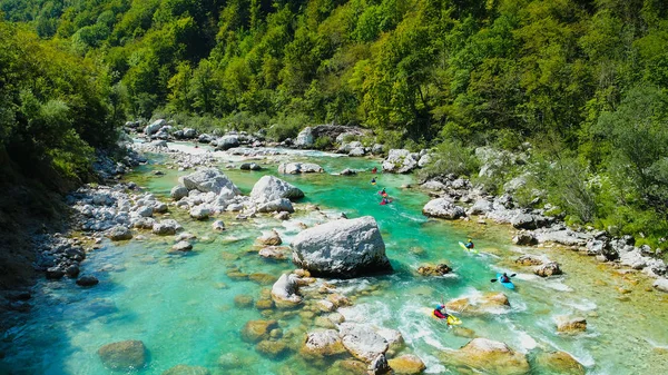 An extreme whitewater Kayaker padding on the Emerald waters of Soca river, Slovenia, are the rafting paradise for adrenaline seekers and also nature lovers, aerial view. — Stock Photo, Image