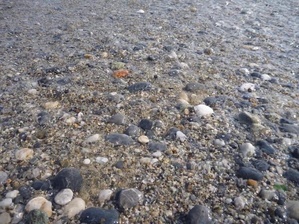 Detail von kleinen runden Steinen am Strand — Stockfoto
