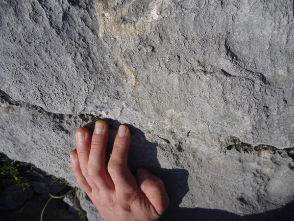 Klimmers hand op een limestone klif tijdens het klimmen — Stockfoto