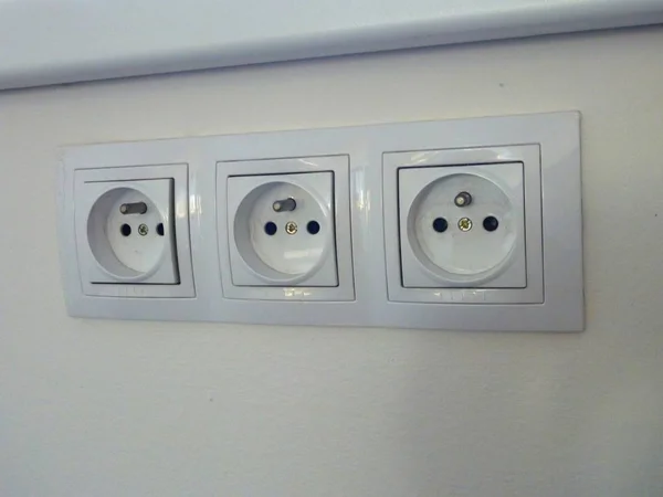 Många vita sockets på en vägg — Stockfoto