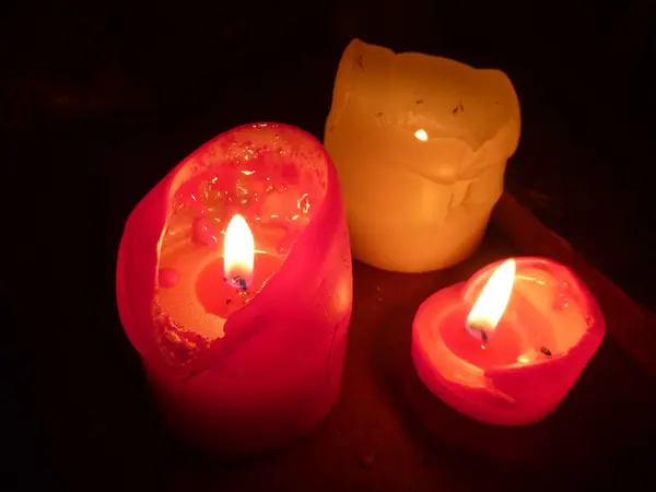 Tres velas encendidas en la oscuridad —  Fotos de Stock