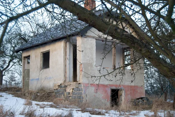 Starý opuštěný zničený dům v zahradě v zimě — Stock fotografie