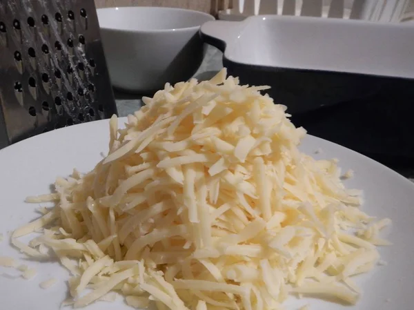 Heap of grated edammer cheece prepared for cooking — Stock Photo, Image