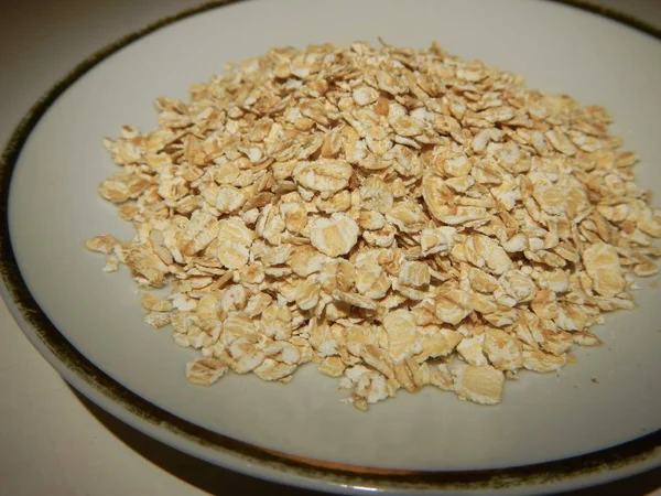 Copos de avena n un plato blanco pequeño — Foto de Stock