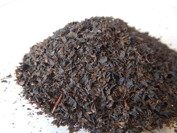 Pequeño montón de hojas de té negro — Foto de Stock