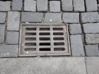 arnavut kaldırımlı bir sokakta ızgara ile su drenaj deliği