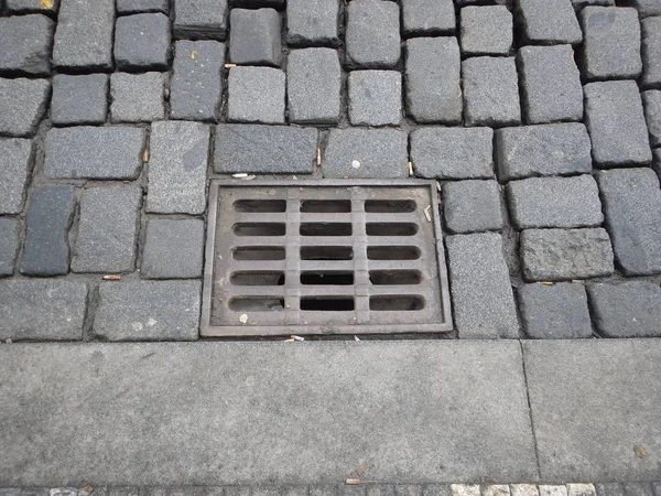 Trou de drainage d'eau avec grille sur une rue pavée — Photo