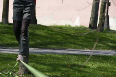 yeşil çim ile bir parkta yalınayak slackline walker