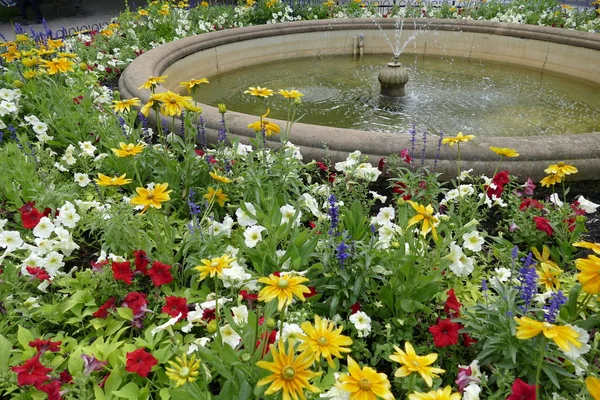 Fonte de água no parque com flores — Fotografia de Stock