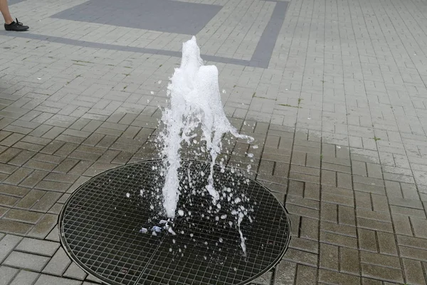 Rotonda fontana d'acqua su un marciapiede — Foto Stock