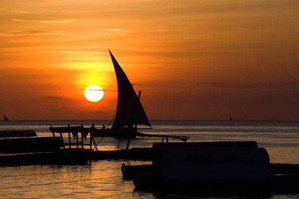 Pôr do sol romântico com um barco no oceano — Fotografia de Stock