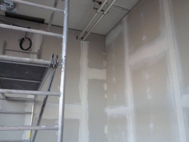  Sıva tahtaları ve merdiveni olan bir bina.