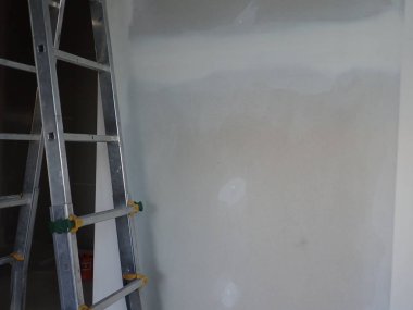  Sıva tahtaları ve merdiveni olan bir bina.