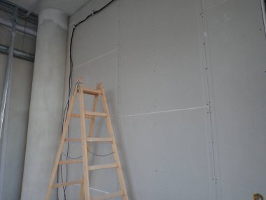  Sıva tahtaları ve merdiveni olan bir bina.