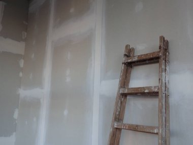  Sıva tahtaları ve merdiveni olan bir bina.