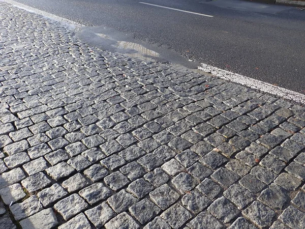 Kullersten asfalt konsistens våt efter regn — Stockfoto