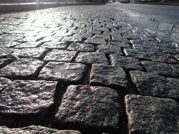 Kullersten asfalt konsistens våt efter regn — Stockfoto