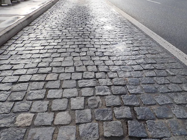 Kullersten asfalt konsistens våt efter regn — Stockfoto