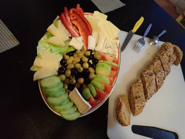 Akşam yemeğinde beyaz tabakta servis edilen çeşitli sebze ve peynir salataları.