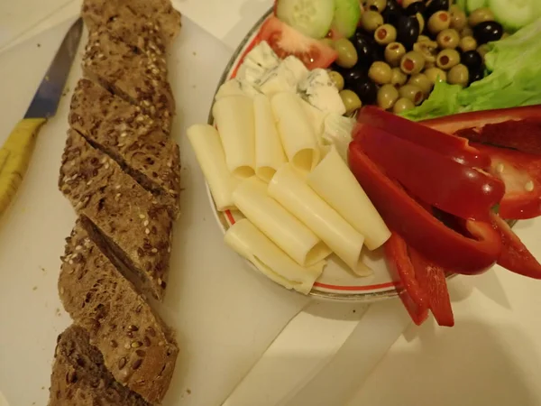 夕食にはホワイトプレートに盛り付けた野菜やチーズのサラダ — ストック写真