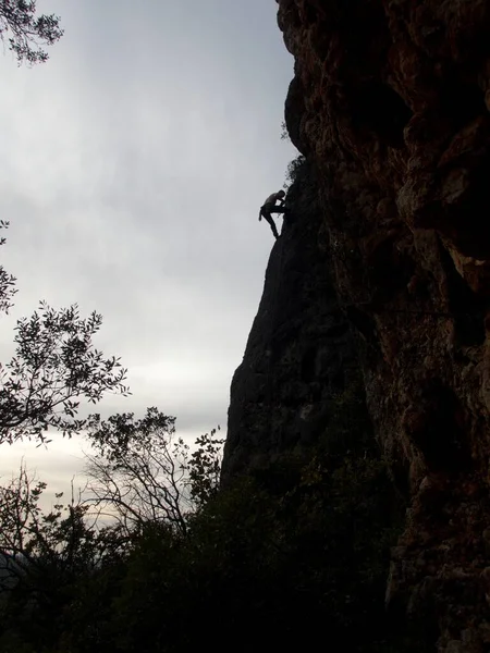 夕日の岩の上にあるクライマーのシルエット — ストック写真