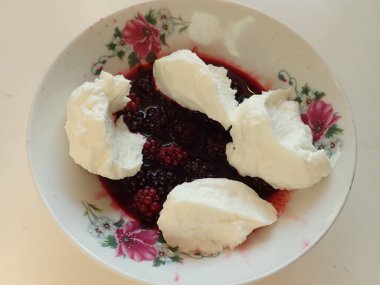 Süslü beyaz kasede kremalı böğürtlenli basit bir atıştırma.