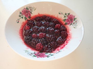 Süslü beyaz kasede kremalı böğürtlenli basit bir atıştırma.