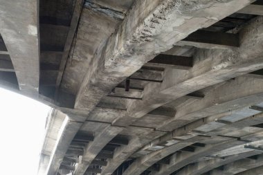 Bir köprünün altında eskimiş beton bir kirişin ince ayrıntıları.