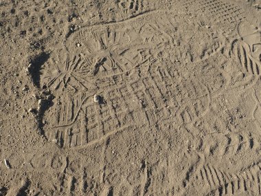 Tozlu bir patikadaki bir yürüyüşçünün çok sayıda ayak izi var.