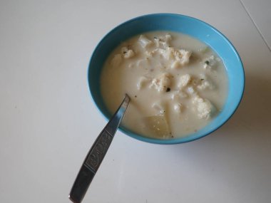 Bir kasede servis edilen beyaz karnabahar sütü çorbası.