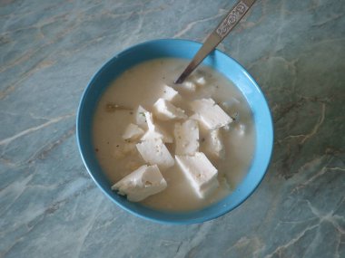 Bir kasede servis edilen beyaz karnabahar sütü çorbası.