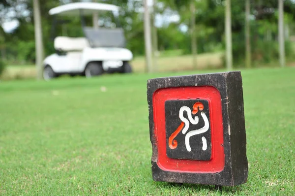 Firme en el tee off con carrito de golf en el campo de golf — Foto de Stock