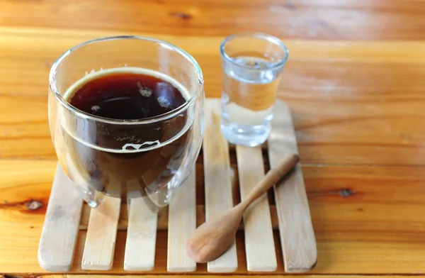 Xícara de café preto quente em placa de madeira — Fotografia de Stock