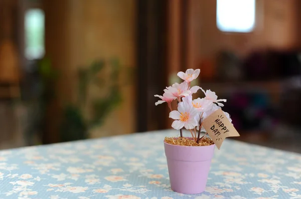 Fleur rose gaie artificielle dans un petit pot en acier avec étiquette Happy Day — Photo