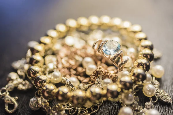 Gouden ring met Topaas en goud armband op parelsnoer — Stockfoto