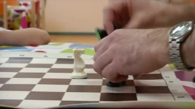 Öğretmen bir çocuğa satranç oynamayı öğretir..