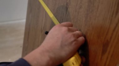 Dekoratif ahşap panellerin yakın görüntüsü, mezura uzunluğu. Minimalist ev tasarımıyla ilgili detaylar ve doğal ahşap uzayda son buluyor.