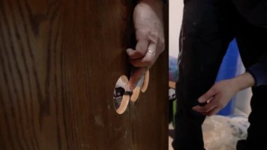 İnşaatçı duvar panelindeki deliği parlatır. Kaplamalı paneller kuruluyor.