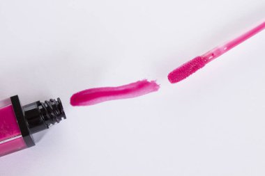 Beyaz arkaplanda pembe dudak parlatıcısı izole edildi