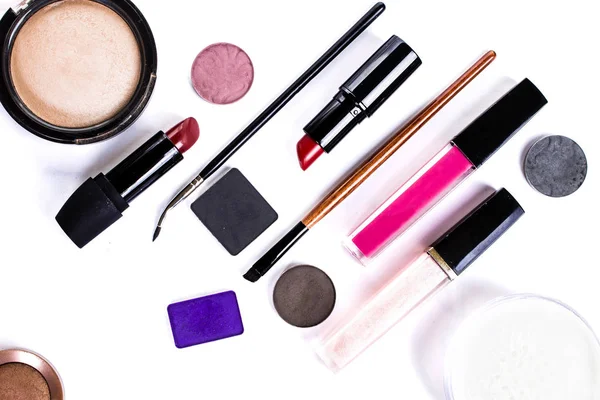 Lipstick, eye shadow, makeup brushes on a white background Royalty Free Stock Photos