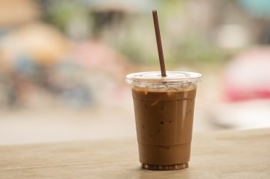 Bir plastik bardak buzlu kahve bir kafede katta yatıyordu
