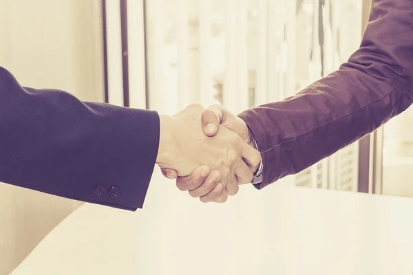 The two businessmen shake hands after successfully doing busines