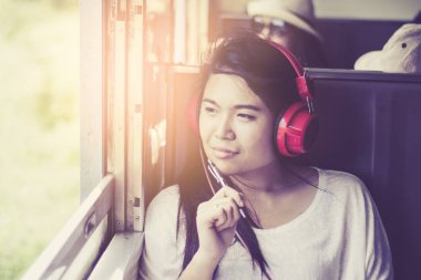 Asyalı kadın t ederken bir tren oturan sırasında müzik