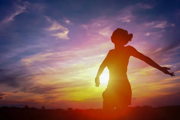 Silhouet van een gelukkige vrouw en zonsondergang — Stockfoto