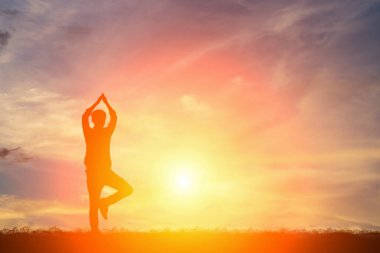 Günbatımı gökyüzü yoga yapan bir erkek silüeti