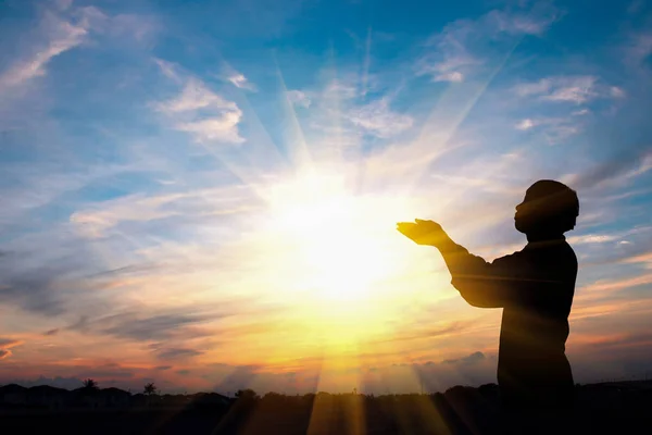 Silhueta de um homem estão orando sobre o pôr do sol fundo — Fotografia de Stock