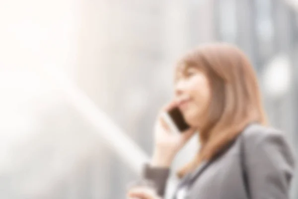 Blurred image of business women Are using smart phones to stay c
