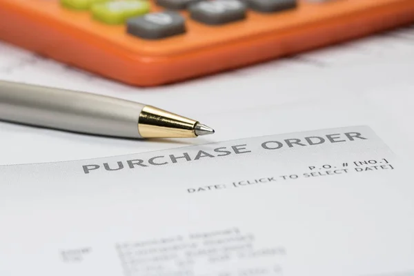 Purchase order form with pen and calculator