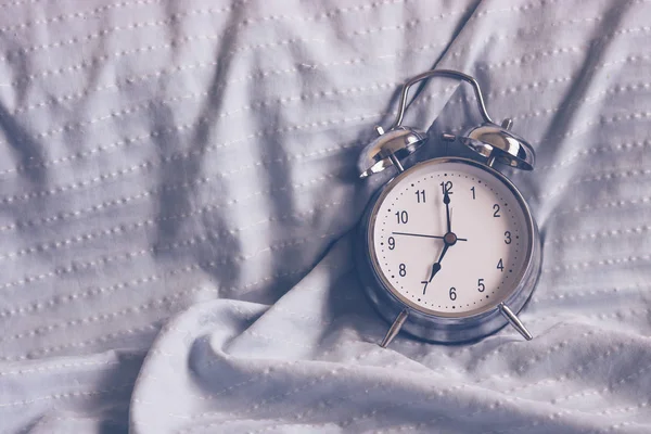 Clock on the bed in the morning. — Stock Photo, Image