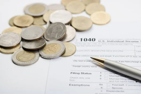 US tax form with pen and coins  selective focus / taxation conc Stock Image